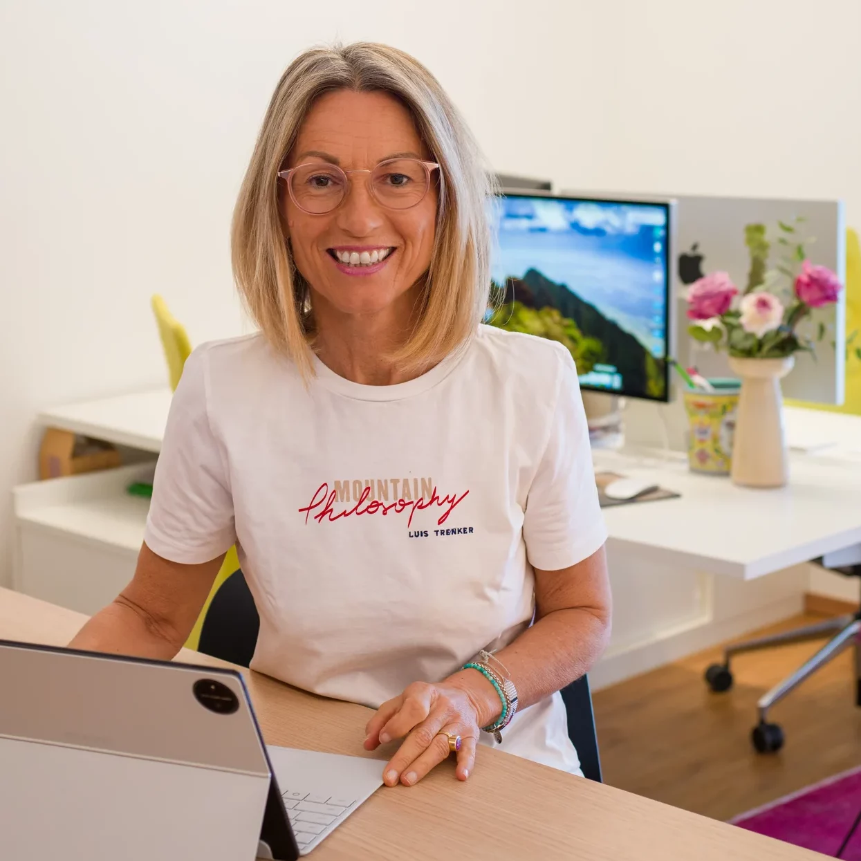 Portraitfoto von Erika Kriechbaumer am Schreibtisch